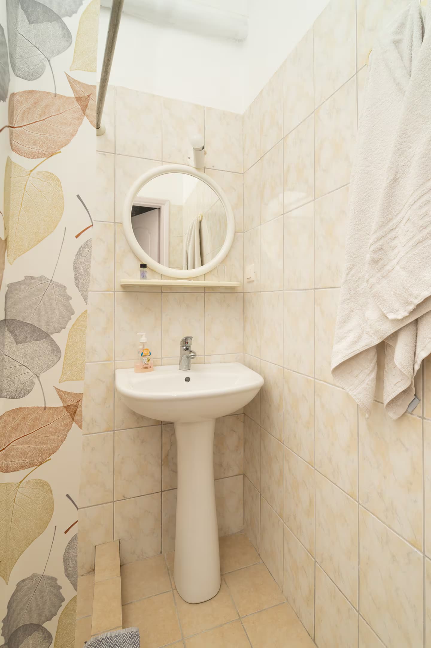 A clean bathroom with a shower, basin and toiletries